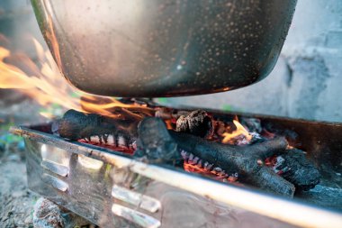 Açık ateşte kazan, ahşap ızgarada güveç çorbası, açık havada yemek.