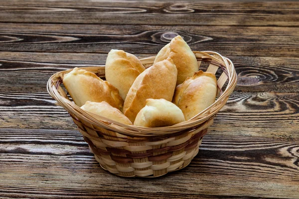 Ahşap arka plan üzerinde sepet'geleneksel Rus börekleri.