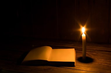 eski antika kitap üzerinde ahşap masa yakınındaki mum yanan ile açıldı. Boş sayfaları