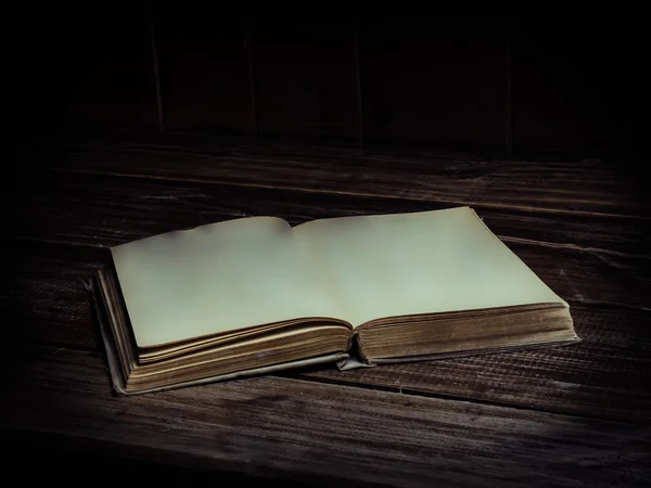 Viejo libro antiguo abierto con páginas en blanco sobre una mesa de madera . Imagen de archivo