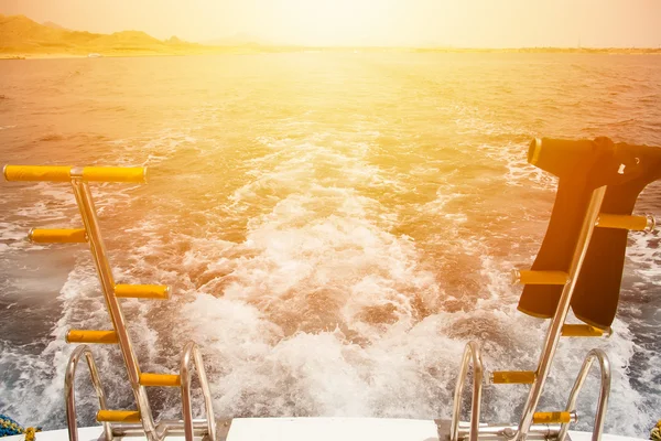 Üstünde-tahta kurutma ile gemi ıslak-arka plan gemi iz dalgalar ve günbatımı giysileri.