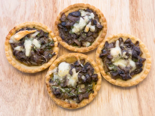 Tartlets mantar ve peynir. Ahşap arka plan.