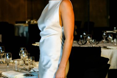 İpek gibi beyaz, minimalist gelinlik içinde zarif bir kadın.