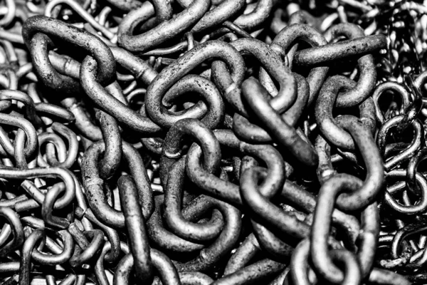 Pile of chains linked together in high contrast black and white