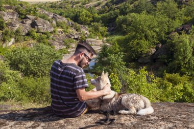 bir kayaya köpekli adama