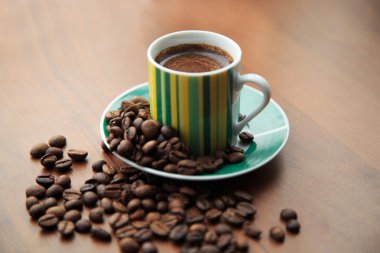 Dağınık kahve çekirdekleri güçlü kahve bir fincan