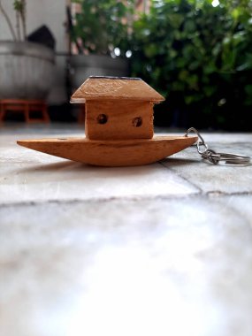 Model tekne oyuncağının anahtarlığı. Beyaz zeminde ahşap tekne. çocukluk anıları ve eski oyuncaklar