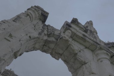 Roma amfi tiyatrosu. Arenanın ve antik harabelerin dış görünüşü. Arkaplanda yağmurlu bir günün gri ve bulutlu gökyüzü.