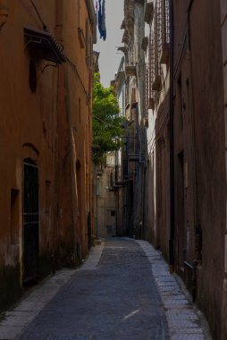 Gün batımında Sant 'Agata dei Goti' nin dar sokakları. Ortasında bir ışık huzmesi ve dar sokaktaki evlerin gölgeleri..