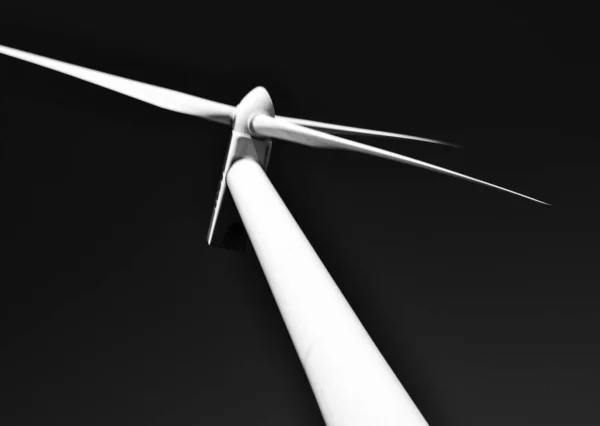 Close-up of a tower wind generator, which stands out against the backdrop of a blue sky. Turbine that saves the environment and produces green energy.