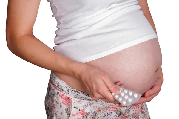 Kobieta w ciąży gospodarstwa pigułki. — Zdjęcie stockowe