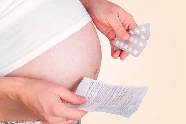Pregnant woman holding pills. Stock Fotografie