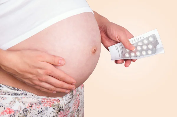 Pregnant woman holding pills. Royalty Free Stock Obrázky