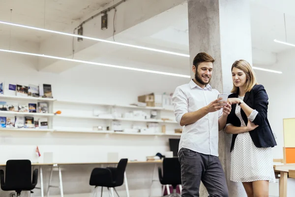 Colleagues smiling while looking at the phone — Stock Photo, Image