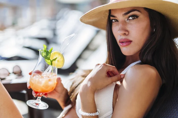 Frau hält beim Sonnenbaden Cocktail in der Hand — Stockfoto