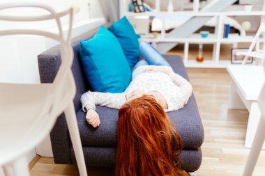 Güzel bir kadın kanepede yatıyor.