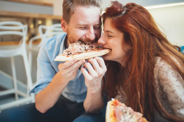 Pasangan berbagi pizza dan makan — Stok Foto