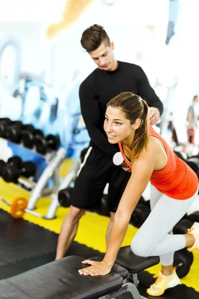 Trainer gibt einer Frau im Fitnessstudio Anweisungen — Stockfoto