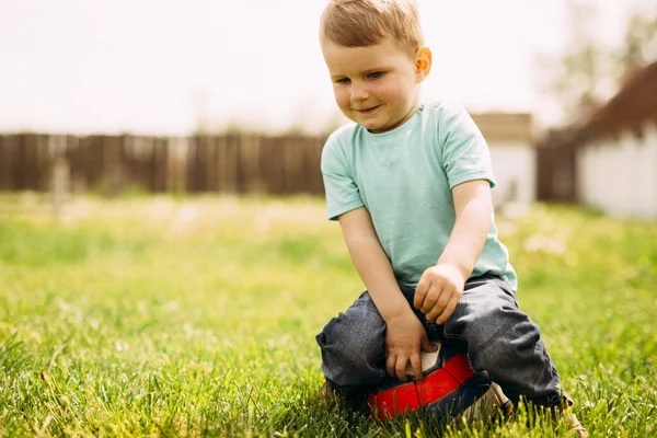 Piccolo ragazzo che gioca con un pallone da calcio all'aperto — Foto Stock