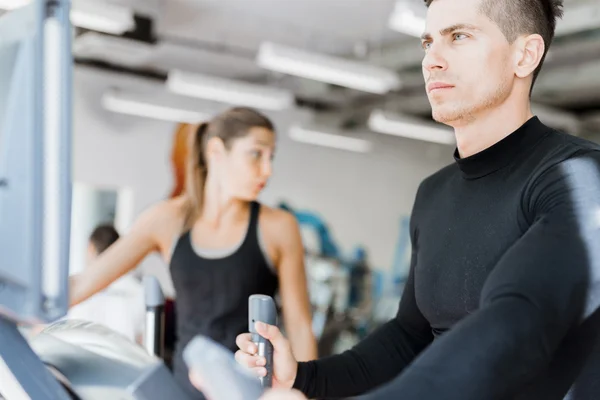 Gente entrenando en un entrenador elíptico — Foto de Stock