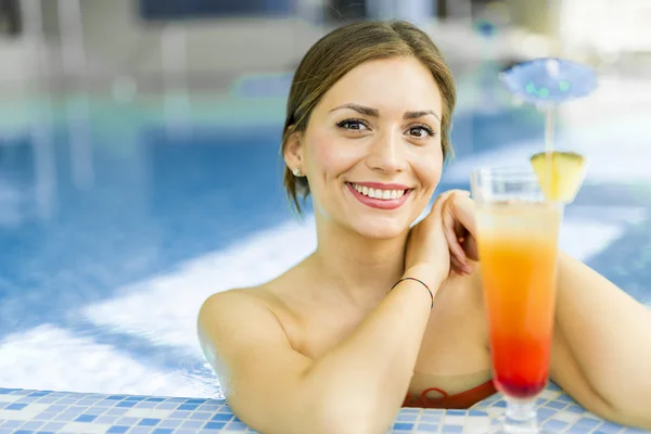 Mujer en una piscina con un cóctel — Foto de Stock