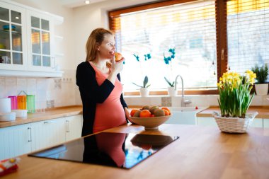 Hamile kadın mutfakta meyve yeme