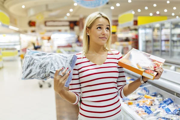 Mulher bonita decidir sobre o que comprar — Fotografia de Stock