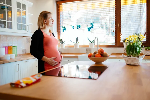 Красивая беременная женщина на кухне — стоковое фото