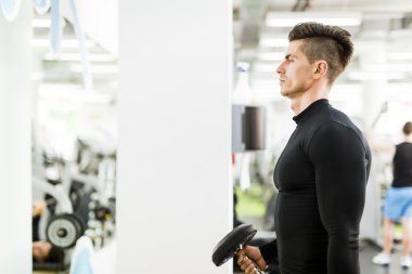 Genç adam bir spor salonunda egzersiz