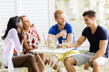 Mutlu arkadaş oturan bir masada konuşurken