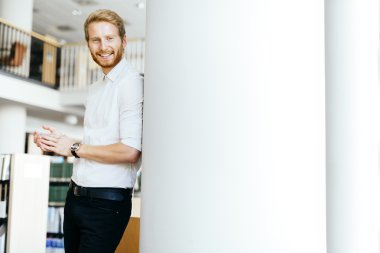 Yakışıklı öğrenci Kitaplığı'nda gülümseyen