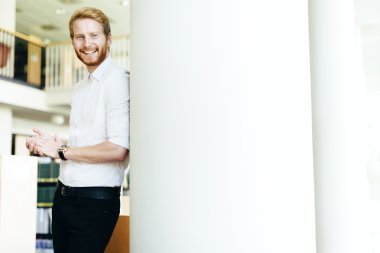 Yakışıklı öğrenci Kitaplığı'nda gülümseyen