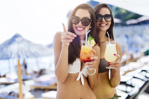 Meisjes drinken van cocktails op het strand — Stockfoto