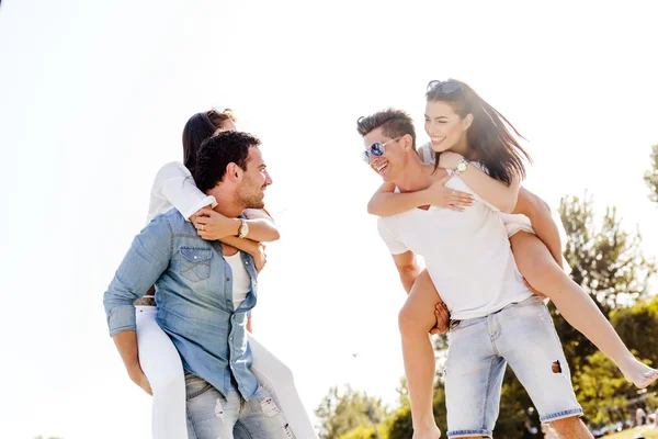 Persone felici che trasportano donne sulla spiaggia — Foto Stock