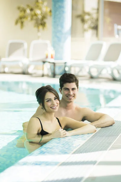 Pareja relajándose al lado de la piscina — Foto de Stock