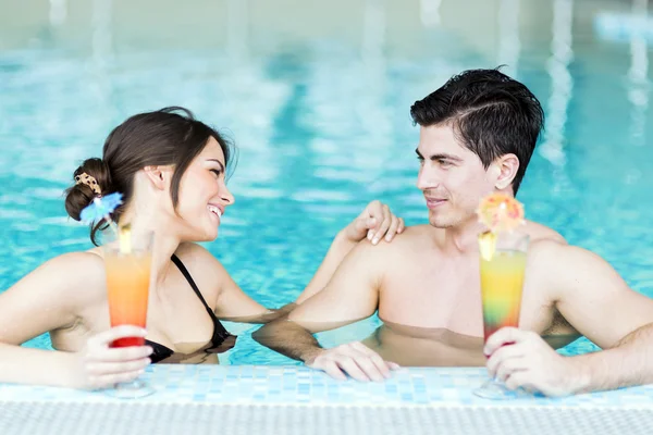 Casal bebendo um coquetel na piscina — Fotografia de Stock