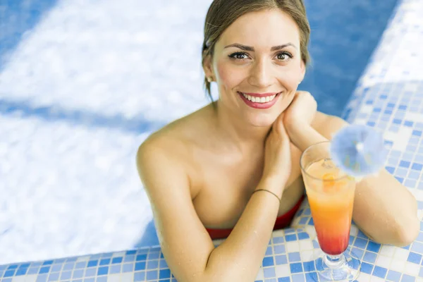 Mujer en una piscina con un cóctel — Foto de Stock