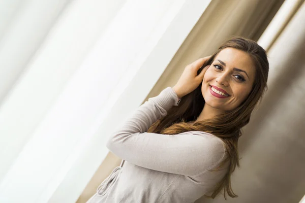 Belle femme posant devant une fenêtre — Photo