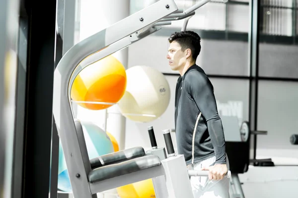 Joven haciendo ejercicio en un gimnasio —  Fotos de Stock