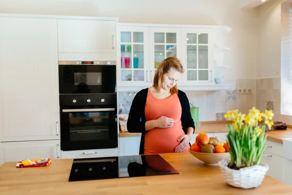 Hermosa mujer embarazada en la cocina —  Fotos de Stock