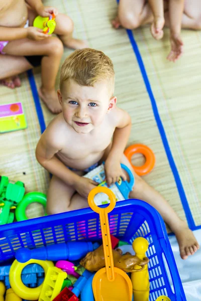 Beautiful kid playing with plastic toys — Stock Photo, Image