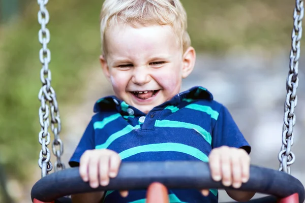 Bambino giocoso su oscillazione all'aperto — Foto Stock