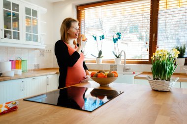 Hamile kadın mutfakta meyve yeme