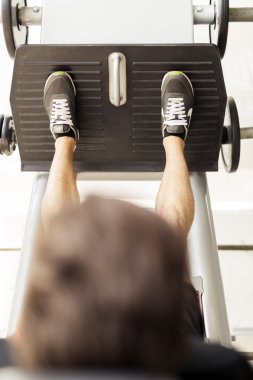 Bacak egzersizleri bir spor salonunda yapan erkek