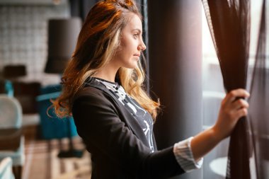 Sarışın kadın pencereden bakıyor