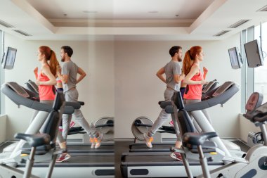 People running on treadmills in gym