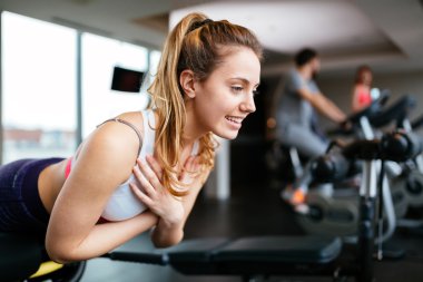 Güzel bir kadın spor salonunda çalışıyor.