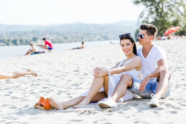 Романтическая пара, сидящая на пляже — стоковое фото