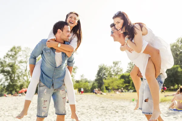 Gruppe von Menschen, die Frauen an einem Strand tragen — Stockfoto