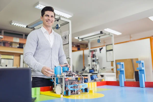 Engenheiro elétrico programando um robô — Fotografia de Stock